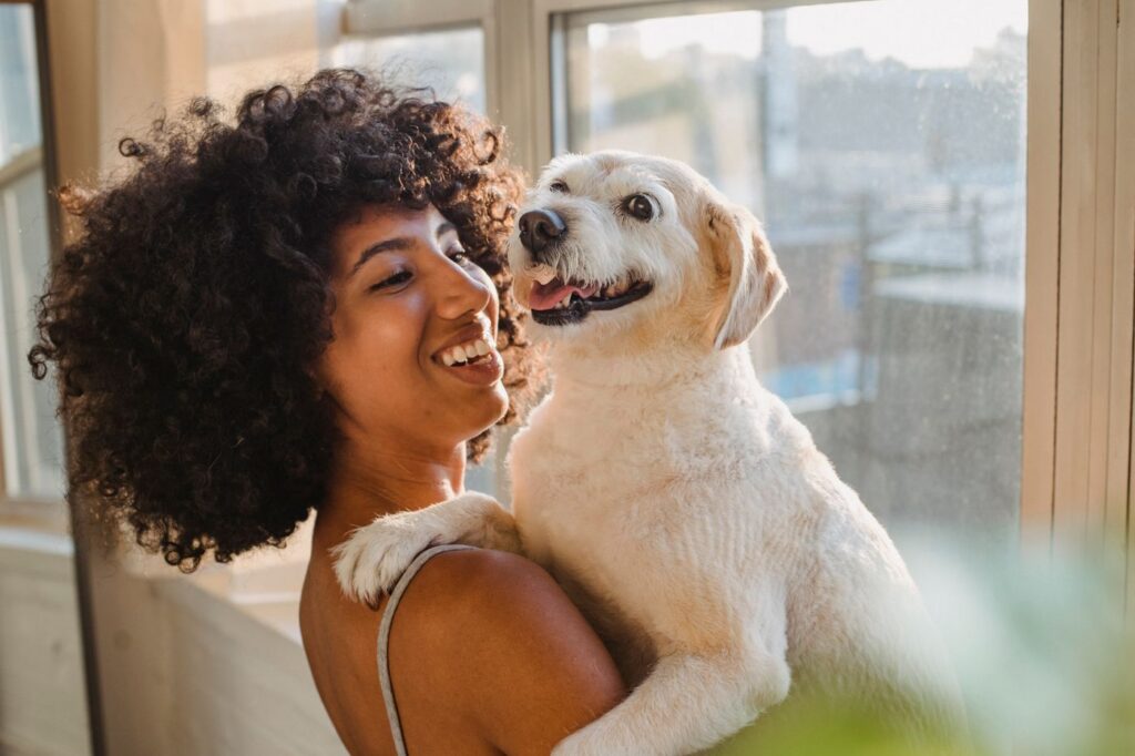 Smiling woman hugging her happy dog